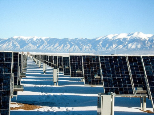 A picture of solar panels in from of the mountains.